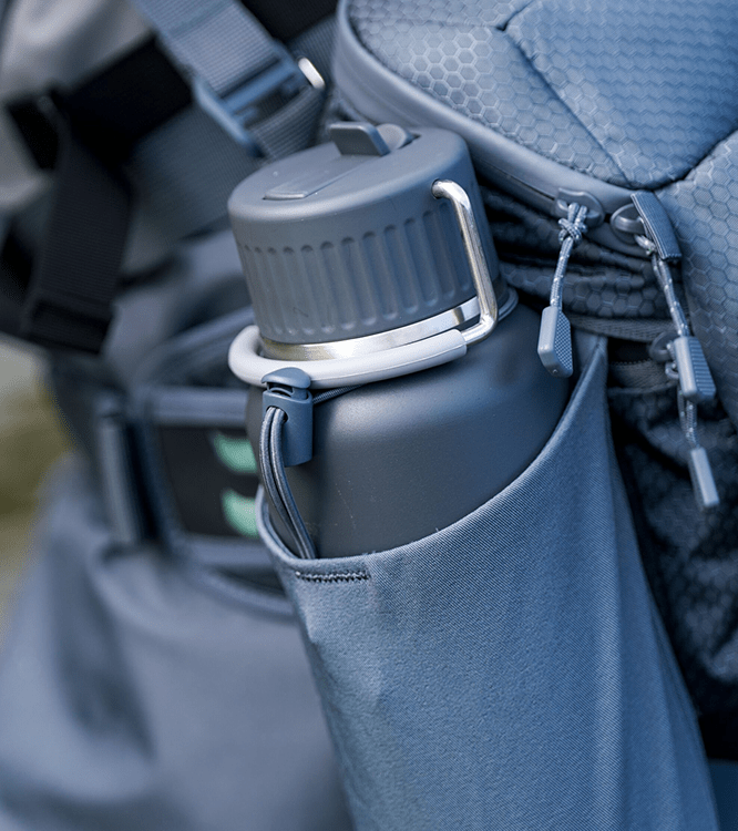 Insulated water bottle in the side pocket of a hiking backpack