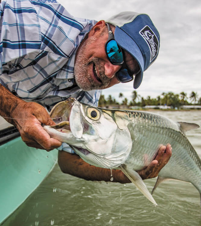 Angler mit polarisierter Sonnenbrille haelt einen Tarpon.